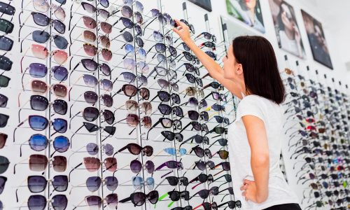 punto-di-vista-posteriore-della-donna-che-controlla-gli-occhiali-da-sole_23-2148273139